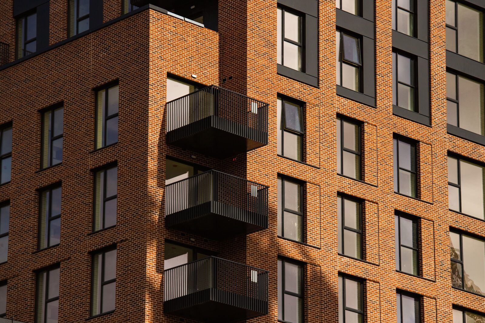 Contemporary brick apartment facade with dark metal balconies, Dublin